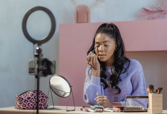 Concentrated African American woman making makeup while filming beauty blog on smartphone in stylish room. Seven public records on social commerce for 2027: what each supports and where it stops