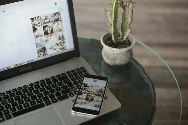 A laptop and smartphone displaying social media apps next to a cactus on a glass table. Social commerce advertising rules: a review process